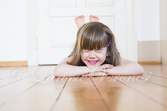 kleines Mädchen auf Holzboden