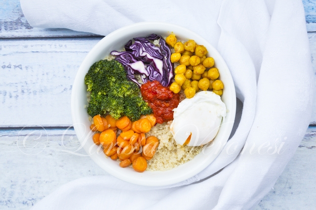 Lunchbowl mit Quinoa, pochiertem Ei, Karotten, Brokkoli, Rotkohl, gerösteten Kichererbsen und Ajvar